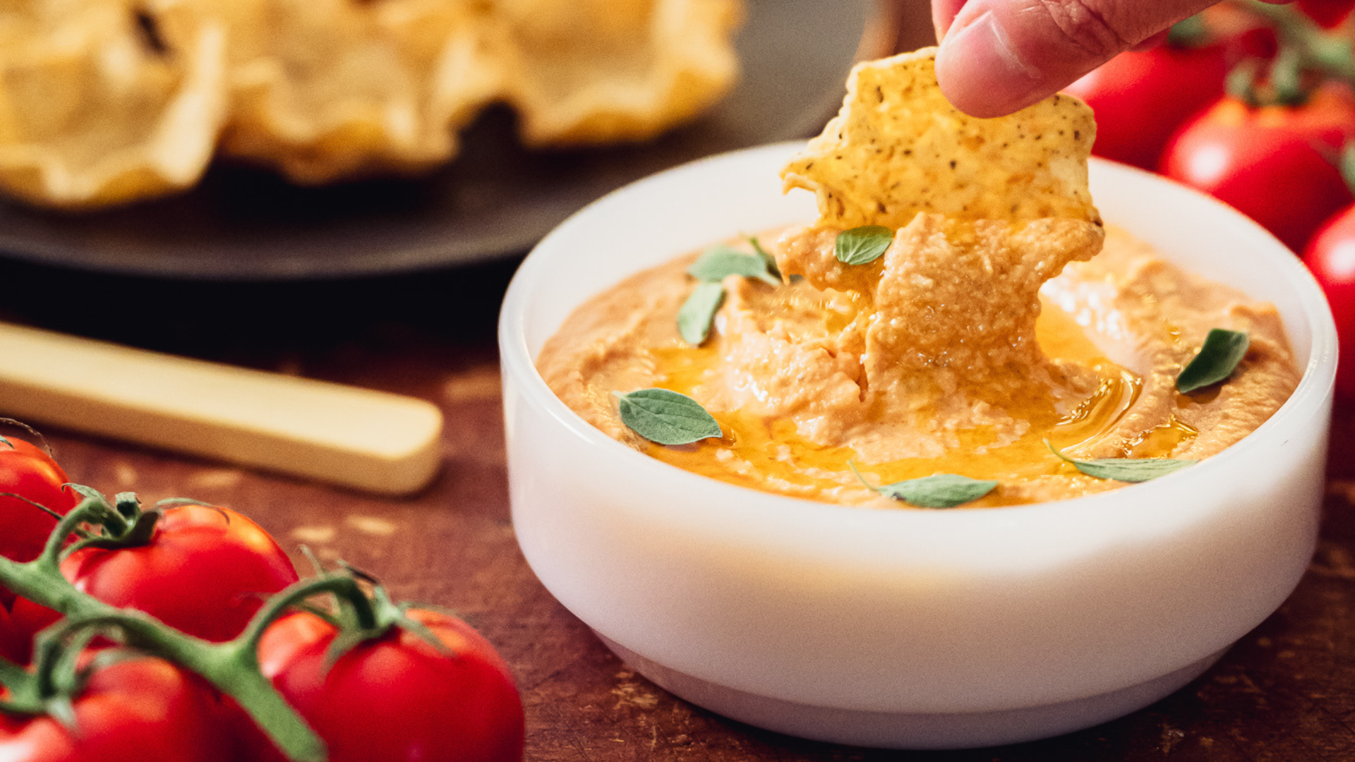 Bol d'houmous aux tomates cerises rôties dans un décor du temps des Fêtes