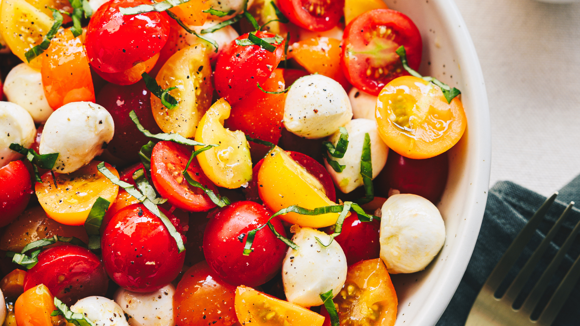 Gros plans sur les ingrédients d'une salade aux tomates tricolores et fromages bocconcinis